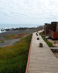 Vertical photo of the pichilemu waterfront with its black sand.