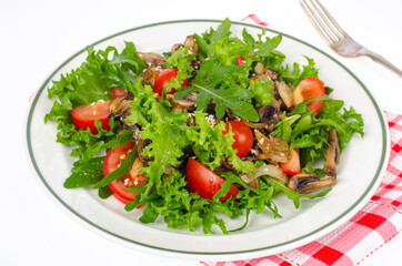 Plate with vegetarian dish of arugula, tomatoes and mushrooms on white background. Studio Photo