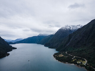 Obraz premium Aerial view of lake tagua tagua with a boat in the center and its snow-capped mountains on the sides and in the background.