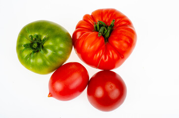 Colored tomatoes of different varieties on white background. Studio Photo