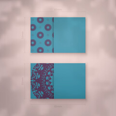 Business card template in turquoise color with Indian purple pattern for your contacts.