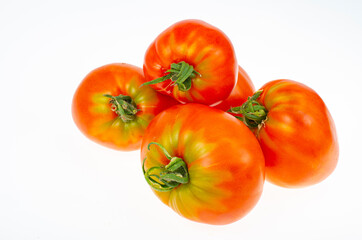Red tomatoes in shape of heart on white background. Studio Photo