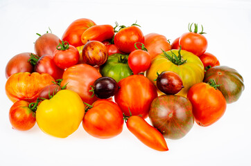 Colored tomatoes of different varieties on white background. Studio Photo