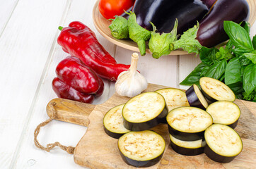 Sliced eggplant slices on wooden board, seasonal vegetables for cooking. Studio Photo