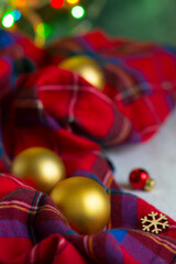 Red checked Christmas and New Year decoration with golden balls and color lights. Blured background