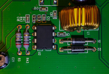 A close-up macro shot of a copper coil of mains voltage for computer (CPU) control, a quartz clock on an electronic printed circuit board (PCB) that is part of the video card control.