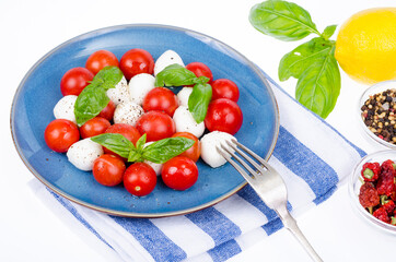 Vegetable salad with mozzarella balls on plate, white background. Studio Photo.