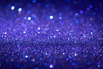 Abstract blue shiny glitter texture. Selective focus. Glowing surface, sparkle lights and bokeh effects. Christmas and festive background