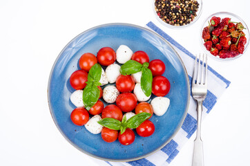 Vegetable salad with mozzarella balls on plate, white background. Studio Photo.