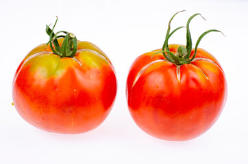 Two ripe red tomatoes with cracked skin. Studio Photo.