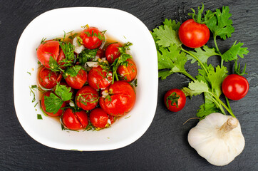 Pickled tomatoes with herbs and garlic. Studio Photo.