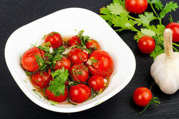 Pickled tomatoes with herbs and garlic. Studio Photo.