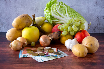 Food lies on a wooden table along with European banknotes and coins symbolizing inflation.