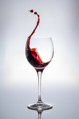 Rotwein spritzt aus einem Weinglas