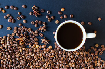 cup with coffee on a dark background and scattered grains of coffee. good morning . kind of sveru. flat lay. place for text. coffee time.
