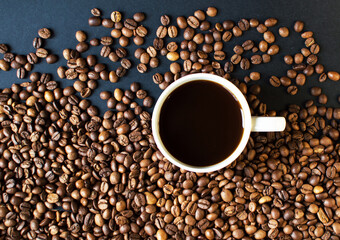 cup with coffee on a dark background and scattered grains of coffee. good morning . kind of sveru. flat lay. place for text. coffee time.

