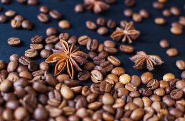 roasted aromatic coffee beans and star anis on a dark background. coffee background. flat lay with place for text. view from above.
