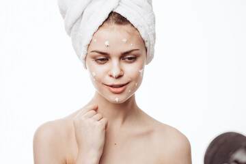 cheerful woman with a white towel on her head face cream skin care