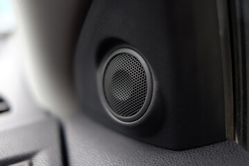 Close-up photo of a black tweeter speaker on a car