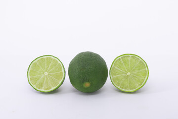 A whole lime and two halfs on a white background
