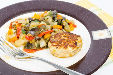 Stewed seasonal vegetables, homemade cutlet for dinner. Studio Photo.