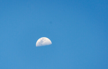 crescent moon in the blue sky, photographed from the equatorial line