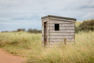 A wood hut for safety from high tides in a wild dune landscape on Spurn Point island