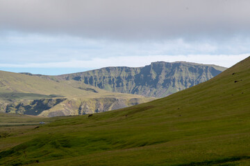 Grassy landscape with mountains and meadow near the Black Sand Beach Vik South Iceland
