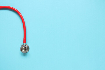 Fototapeta na wymiar Top view of red stetoscope on blue background. Medicine concept.