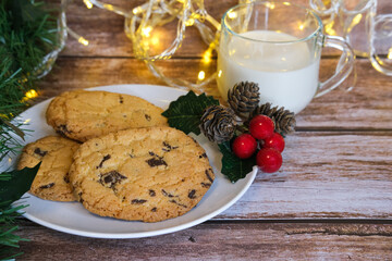 Milk with Christmas cookies for santa claus on a wooden table, selective focus.