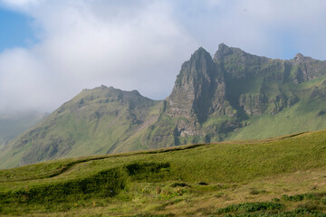 Grassy landscape of cliffs and meadow near the Black Sand Beach Vik South Iceland