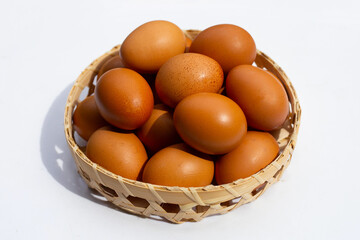Chicken eggs in bamboo basket on white.