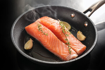 slices of fresh salmon fillet are gently fried on the skin in a black saute pan with garlic, thyme...