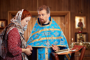 a woman repents of her sins, confessions with a priest in an Orthodox church