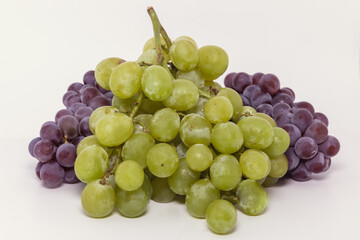Bunches of pink niágara grapes and italy green grapes on a white background.