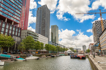 Fototapeta premium Motorboats moored in channel with downtown skyscrapers in the background, Rotterdam. The Netherlands