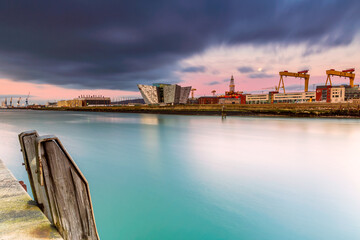 Sunset over Titanic Belfast - museum, touristic attraction and monument to Belfast's maritime heritage on the site of the former Harland and  - obrazy, fototapety, plakaty