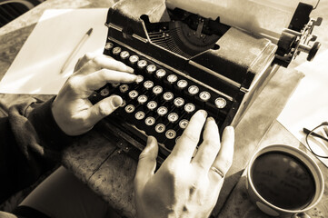 Male writer writing his book on an old antique typewriter. An old antique typewriter.