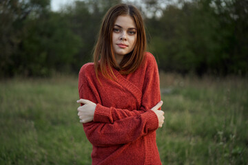 woman in a red sweater outdoors in the field nature rest