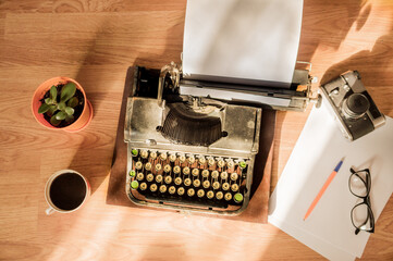 Old antique typewriter with inserted paper for writing articles and books on the desktop.