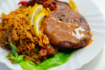 Meat free burger and long grain rice with red peppers, tomatoes and jalapeno chillies