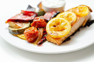 Grilled salmon fillet served with roasted vegetables with cucumber and dill sauce
