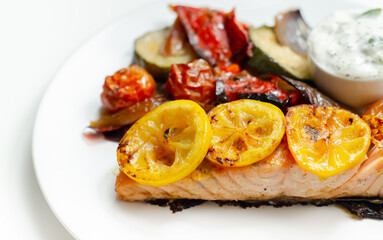 Grilled salmon fillet served with roasted vegetables with cucumber and dill sauce