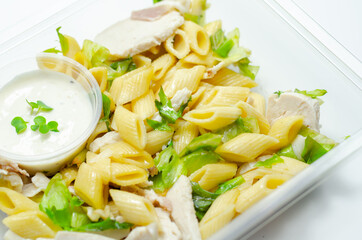 Penne pasta in a mayonnaise dressing with bacon pieces topped with parsley rubbed cooked chicken...