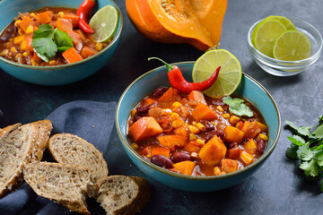 Feuriges Chili con Kürbis aus der veganen Küche mit Limette und Koriander– Hot vegan chili con calabaza from the vegan cuisine with lime and coriander served with slices of a wholemeal roll