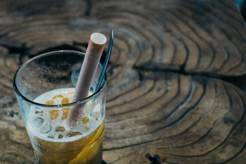 Iced drinks on the wooden table, using paper straw