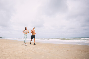 Runners. Young couple running on beach.