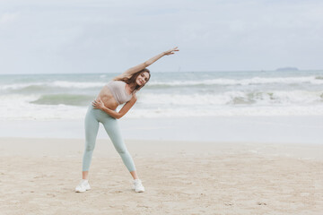 fitness, sport, and lifestyle concept - couple making yoga exercises on beach,  Man and woman doing yoga exercise on the beach.