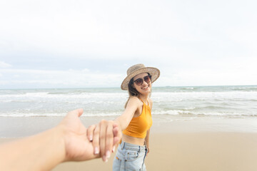 woman holding hand man. follow me concept. walking by sandy sea beach on sunset. Woman relaxing at beach enjoying summer freedom