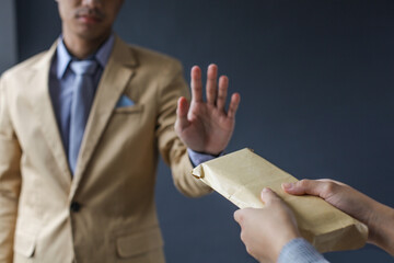 A businessman rejecting money in the envelope.
